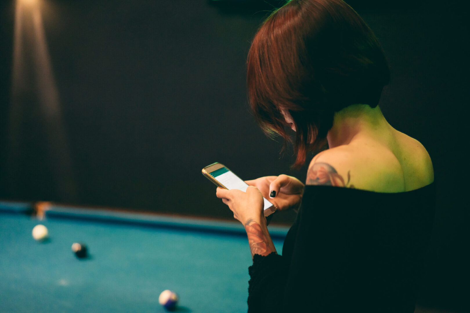 Person using phone near billiards